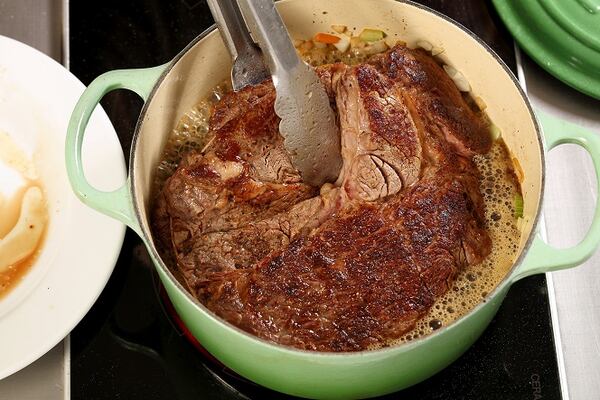 Return the browned roast to the Dutch oven, adding enough liquid to come halfway up the side of the meat. (Michael Tercha/Chicago Tribune/TNS)