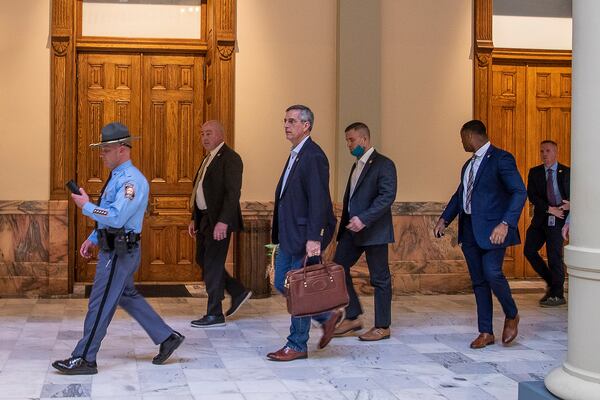 Lead by a Georgia state trooper, Georgia Secretary of State Brad Raffensperger (third from left) exits the Georgia State Capitol in downtown Atlanta following reports of threats on January 6, 2021. (Alyssa Pointer / Alyssa.Pointer@ajc.com)