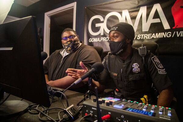 Officer Ralph Coquemar (right) speaks to a virtual audience with commentator Malik Andrews (left) after losing to teenagers in a video game Monday.