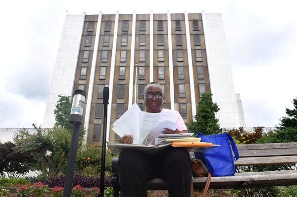 Dee Smith, a member of the NAACP, sifts through her papers needed to make history. Smith is is leading an effort to make DeKalb County the first in Metro Atlanta to officially partner with the Equal Justice Initiative in recognizing the lynchings that took place in the county. Behind Smith is the DeKalb County Courthouse, the purposed site for the memorial. The NAACP is organizing a series of events that will include the unveiling of two lynching markers. An EJI lynching monument is also in the works. RYON HORNE / RHORNE@AJC.COM