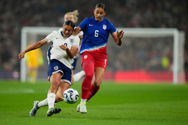 England's Jessica Carter, left, and United States' Lynn Williams challenge for the ball during the International friendly women soccer match between England and United States at Wembley stadium in London, Saturday, Nov. 30, 2024. (AP Photo/Kirsty Wigglesworth)