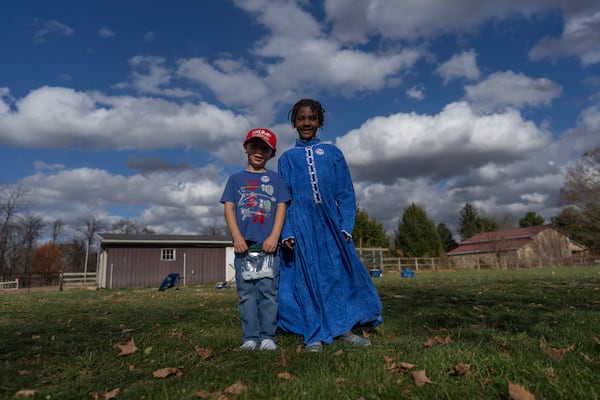 Gianna Young, 7, right, and Isaac Young, 5, pose for a photo on their farm before going to vote with adoptive parents Mike and Erin Young on Election Day, Tuesday, Nov. 5, 2024, in Sunbury, Ohio. (AP Photo/Carolyn Kaster)