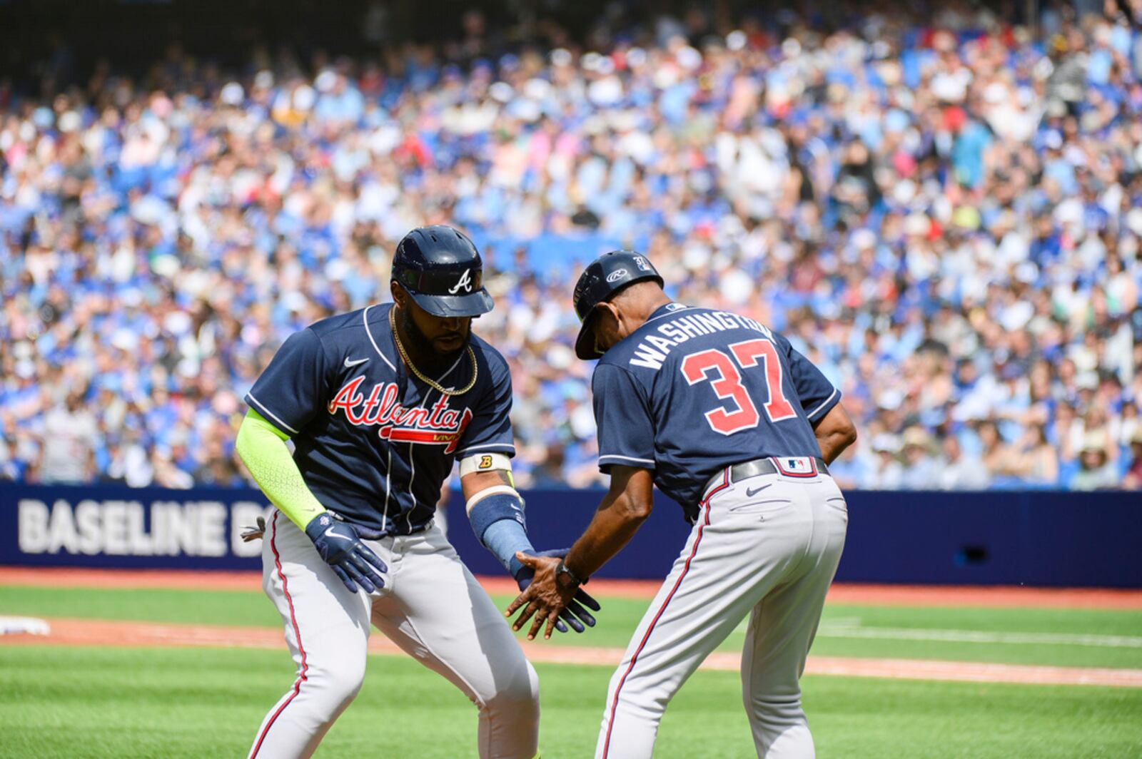 Braves designated hitter Marcell Ozuna (20) and Braves third base coach Ron Washington (37) celebrate after Ozuna hit a two-run home run in the second inning of a baseball game against the Toronto Blue Jays, Saturday, May 13, 2023, in Toronto. (Christopher Katsarov/The Canadian Press via AP)