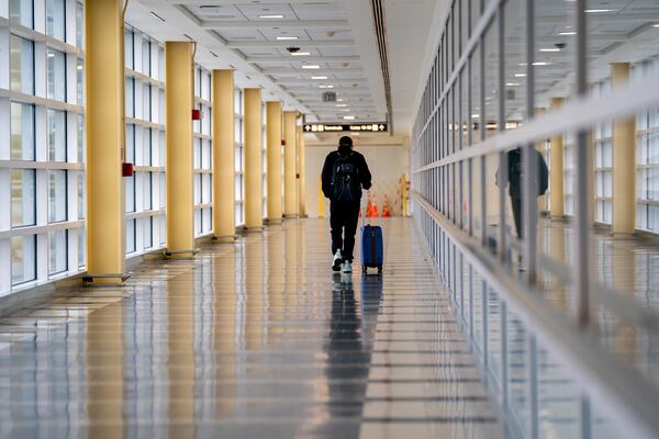 In this file photo, a traveler walks alone Ronald Reagan Washington National Airport in Arlington on Nov. 22. (Stefani Reynolds/The New York Times)