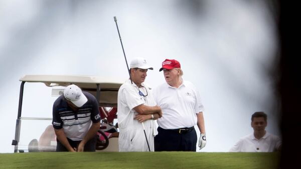 President Donald Trump talks to a caddie during a round of golf at Trump International Golf Club in West Palm Beach, Florida on April 5, 2017. (Allen Eyestone / The Palm Beach Post)