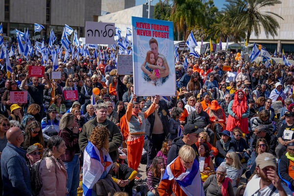 People watch a live broadcast from the funeral of slain hostages Shiri Bibas and her two children, Ariel and Kfir, at a plaza known as the Hostages Square in Tel Aviv, Israel, on Wednesday, Feb. 26, 2025. The mother and her two children were abducted by Hamas on Oct. 7, 2023, and their remains were returned from Gaza to Israel last week as part of a ceasefire agreement with Hamas. (Ariel Schalit/AP)