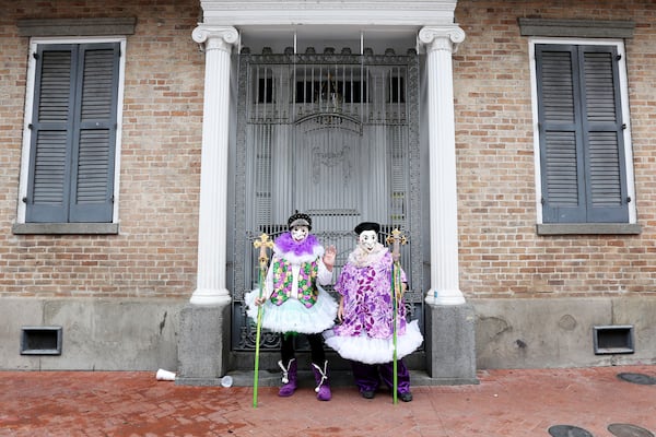 FILE - Jeff Thomas and Shelton Pollet find a rare peaceful spot on Bourbon Street during Mardi Gras festivities in New Orleans, Feb. 25, 2020. (AP Photo/Rusty Costanza, File)