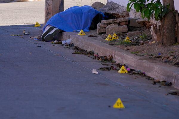 The body of a slain woman is covered with a blanket in Culiacan, Sinaloa state Mexico, Wednesday, Feb. 26, 2025. (AP Photo/Fernando Llano)