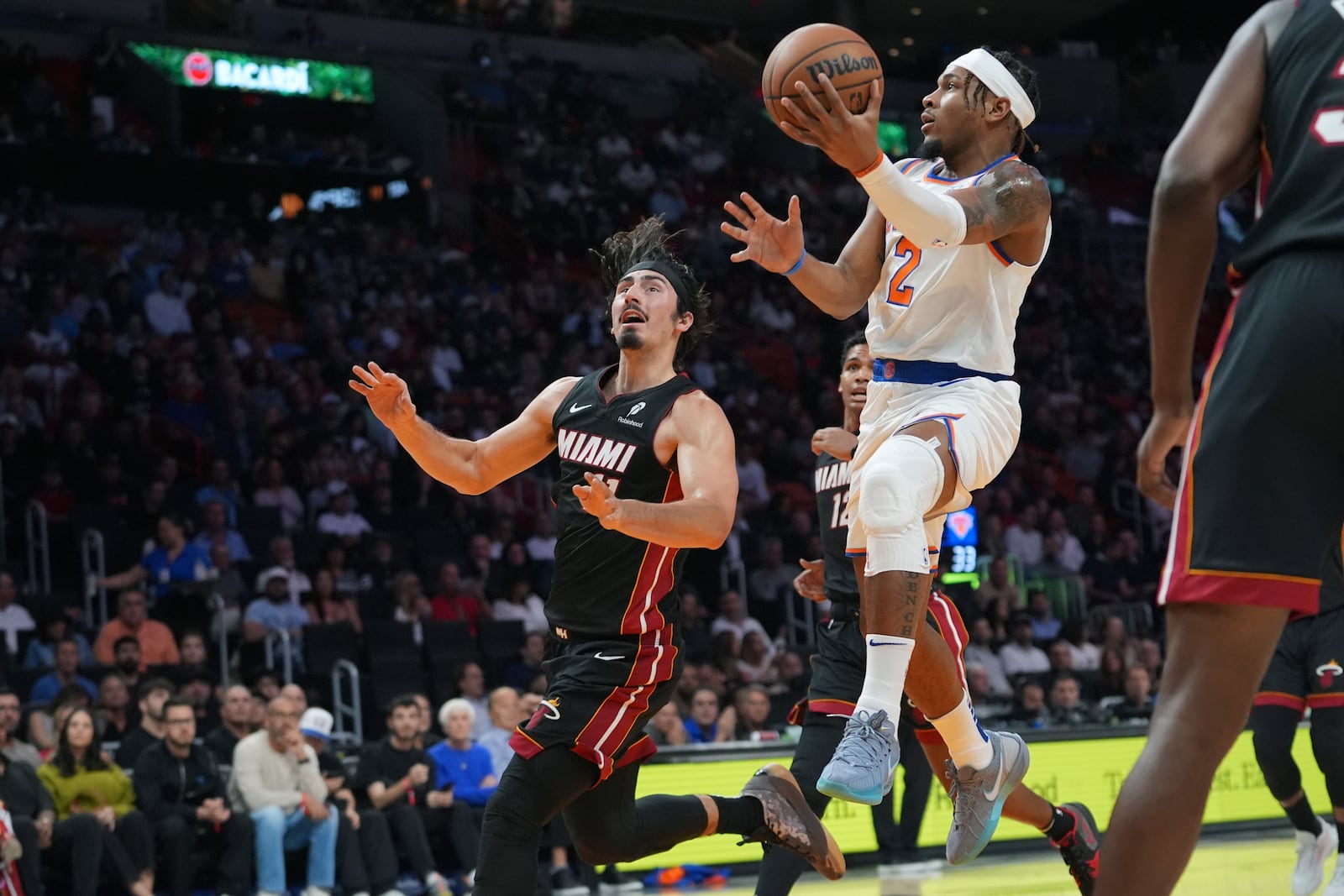 New York Knicks guard Miles McBride (2) goes to the basket as Miami Heat guard Jaime Jaquez Jr., left, defends during the first half of an NBA basketball game, Wednesday, Oct. 30, 2024, in Miami. (AP Photo/Lynne Sladky)