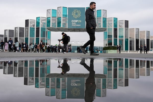 People arrive for the day at the COP29 U.N. Climate Summit, Tuesday, Nov. 19, 2024, in Baku, Azerbaijan. (AP Photo/Joshua A. Bickel)