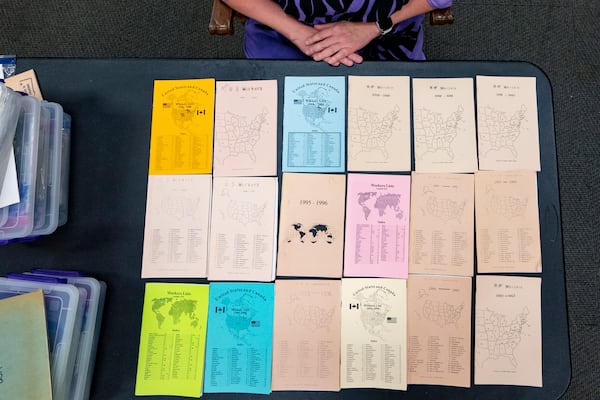 Pam Walton shows lists of the "Two by Twos" workers who attended some of the sect’s annual meetings from 1992 to 2003, while at a library, Monday, Dec. 9, 2024, in Wailea, Hawaii. Walton uses the lists and other documents to track the movements of spiritual leaders with child sex abuse allegations. (AP Photo/Mengshin Lin)