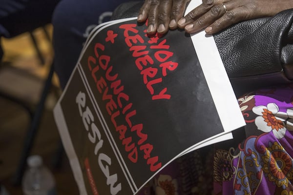 Hoschton resident Mary Morrison holds a sign urging for the resignation of Hoschton Mayor Theresa Kenerly and Councilman Jim Cleveland during a city council meeting at the Hoschton Historic Train Depot in Hoschton, Monday, May 6, 2019. (ALYSSA POINTER/ALYSSA.POINTER@AJC.COM)