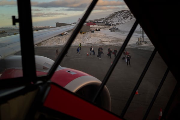 People disembark from a plane as they arrive at the International airport in Nuuk, Greenland, Friday, Feb. 14, 2025. (AP Photo/Emilio Morenatti)