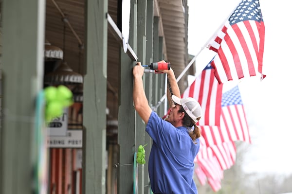 Micah Money with City of Plains fixes a flag pole bracket on Main Street, Friday, Feb. 24, 2023, in Plains, GA. (Hyosub Shin / Hyosub.Shin@ajc.com)