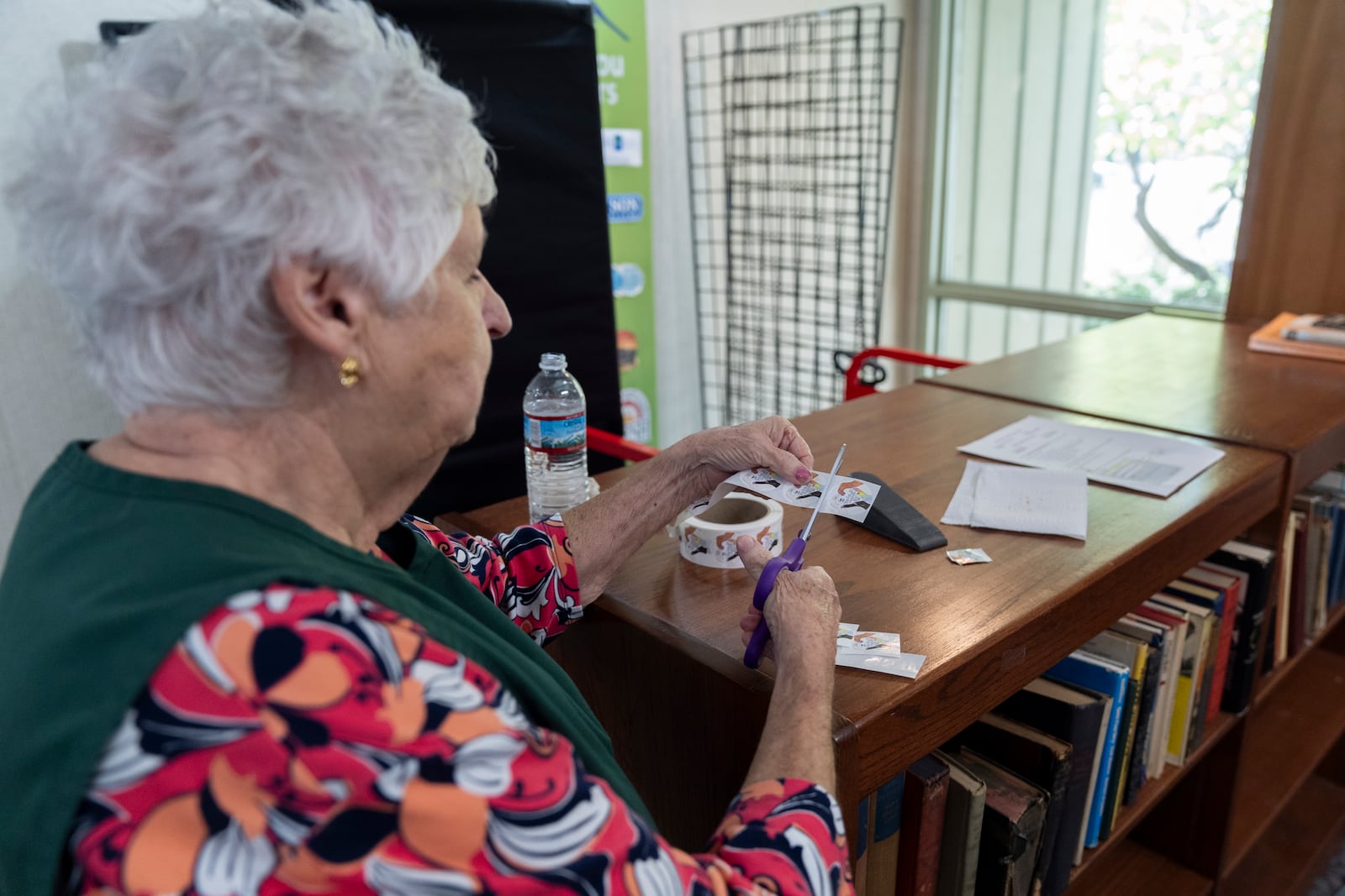 An election official prepares stickers for voters who have cast their ballots during the first day of early in-person voting in Black Mountain, N.C., Thursday, Oct. 17, 2024. (AP Photo/Stephanie Scarbrough)