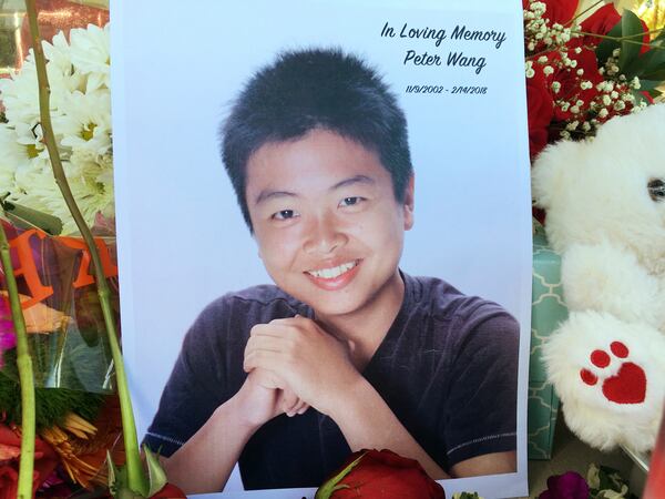 HOLD FOR AARON- Peter Wang is seen in this photo near a memorial in Parkland, Fla., Friday, Feb. 16, 2018. Wang, a student at Marjory Stoneman Douglas High School in Parkland, Fla., was killed when former student Nikolas Cruz opened fire at the school Wednesday, Feb. 14, 2018. (AP Photo/Allen Breed)