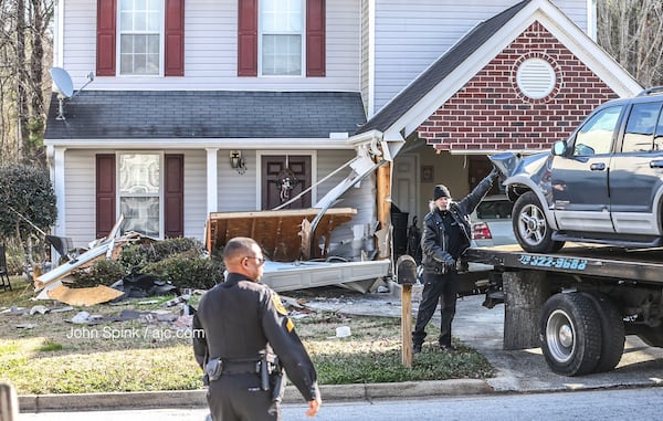 A stolen Ford SUV is towed away after it crashed Friday morning. JOHN SPINK / JSPINK@AJC.COM