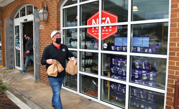 Billy Kramer, owner of NFA Burger, is constantly running food to customers waiting outside in cars and at picnic tables at NFA Burger.  (CHRIS HUNT FOR THE ATLANTA JOURNAL-CONSTITUTION)