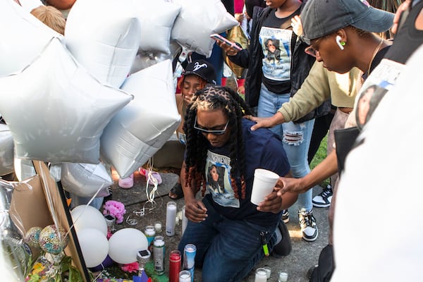 Akeyia Williams (center) pays her respects during the candlelight vigil for Koko Da Doll on Saturday, April 22, 2023, in Atlanta. Koko was a Black trans woman who was murdered this week and was the star of "Kokomo City," an upcoming documentary that highlights the experiences of trans sex workers that premiered at the Sundance Film Festival earlier this year. CHRISTINA MATACOTTA FOR THE ATLANTA JOURNAL-CONSTITUTION.