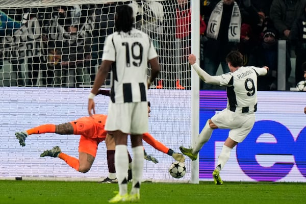 Juventus' Dusan Vlahovic, right, scores his side's first goal during the Champions League, opening phase soccer match between Juventus and Manchester City at the Allianz stadium in Turin, Italy, Tuesday, Wednesday, Dec.11, 2024. (AP Photo/Luca Bruno)