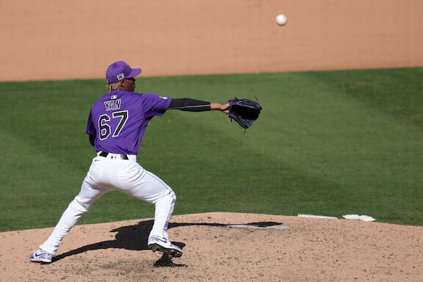 Colorado Rockies pitcher Jefry Yan tries to make a play on an infield ground ball hit by Seattle Mariners' Colt Emerson during the seventh inning of a spring training baseball game Sunday, March 2, 2025, in Scottsdale, Ariz. (AP Photo/Ross D. Franklin)