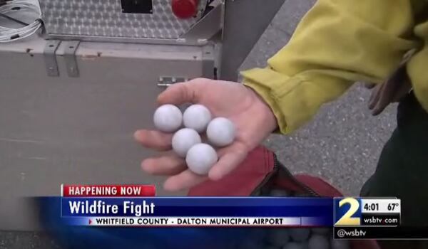 An official holds fire-inducing spheres that are being dropped in the area of a North Georgia wildfire. (Credit: Channel 2 Action News)