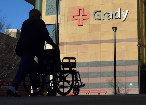 An employee of Grady Memorial Hospital returns a wheelchair. BRANT SANDERLIN / 2014 AJC file photo