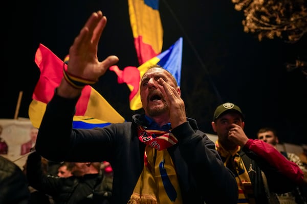 Supporters of Calin Georgescu react during a protest after Romania's Constitutional Court upholded a ban on his candidacy in the presidential election rerun, in Bucharest, Romania, Tuesday, March 11, 2025. (AP Photo/Vadim Ghirda)