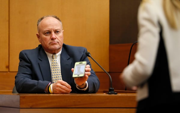 4/16/18 - Atlanta - Jay Grover, who worked for Diane McIver at U.S. Enterprises, shows a photo of rain boots similar to what he bought for her to Defense attorney Amanda Clark Palmer  during the Tex McIver murder trial at the Fulton County Courthouse on Thursday, April 12, 2018. Bob Andres bandres@ajc.com