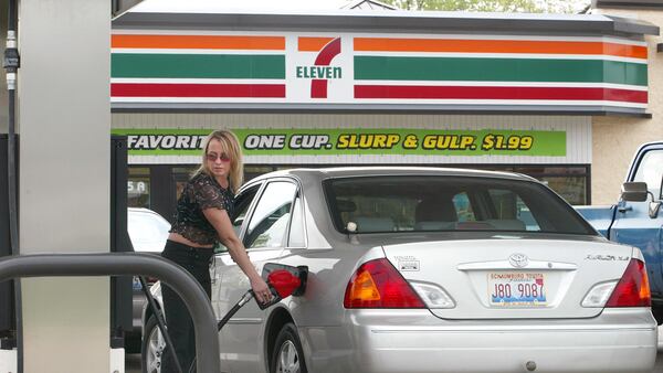 A customer pumps gas at a 7-Eleven store.