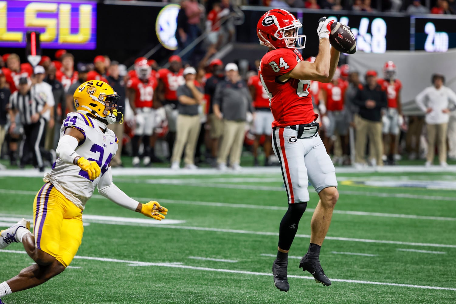 Georgia Bulldogs wide receiver Ladd McConkey (84) makes a 22-yard touchdown reception over LSU Tigers cornerback Jarrick Bernard-Converse (24) during the first half of the SEC Championship Game at Mercedes-Benz Stadium in Atlanta on Saturday, Dec. 3, 2022. (Bob Andres / Bob Andres for the Atlanta Constitution)