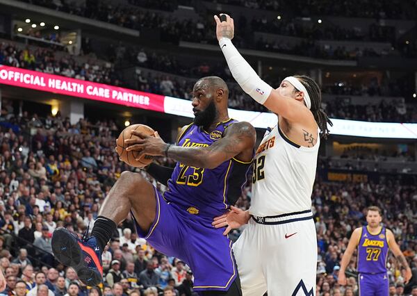 Los Angeles Lakers forward LeBron James, left, pulls in a rebound as Denver Nuggets forward Aaron Gordon defends in the first half of an NBA basketball game Saturday, Feb. 22, 2025, in Denver. (AP Photo/David Zalubowski)