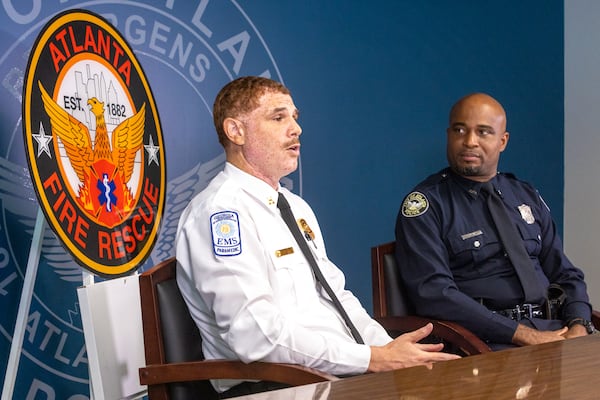 (L-R) Atlanta Fire & Rescue Department Fire Capt. Terrance Simon and Atlanta Police Department Officer Rayando Bryan speak during a press conference in Atlanta on Monday about rescuing a man from a vehicle during last week’s flash flood. (Arvin Temkar / arvin.temkar@ajc.com)