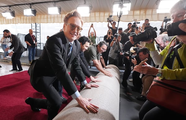 Conan O'Brien, host of Sunday's 97th Academy Awards, helps to roll out the red carpet for the show at the Dolby Theatre on Wednesday, Feb. 26, 2025, in Los Angeles. (AP Photo/Chris Pizzello)