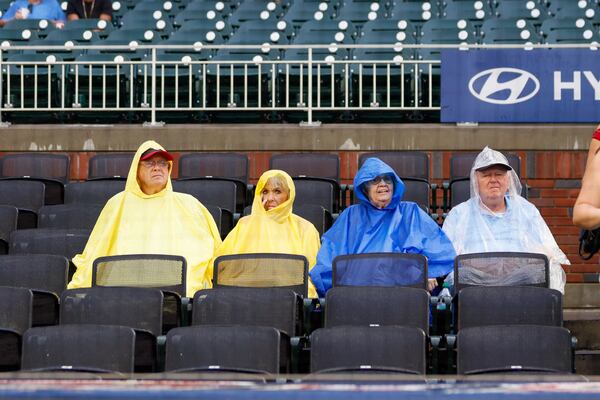 Despite the rain at Truist Park, hopeful fans are seen covering themselves with ponchos as they await the start of the game between the Atlanta Braves and the Cincinnati Reds. The game is currently under a weather delay at Truist Park on Tuesday, July 23, 2024, in Atlanta.
(Miguel Martinez/ AJC)