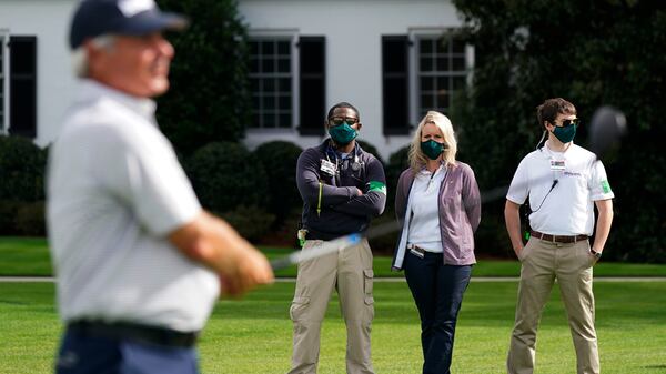 Medical workers watch as Fred Couples tees off on the 10th hole during a practice round for the Masters Tournament Monday, Nov. 9, 2020, in Augusta, Ga. The Masters this November will be played without spectators. (David J. Phillip/AP)