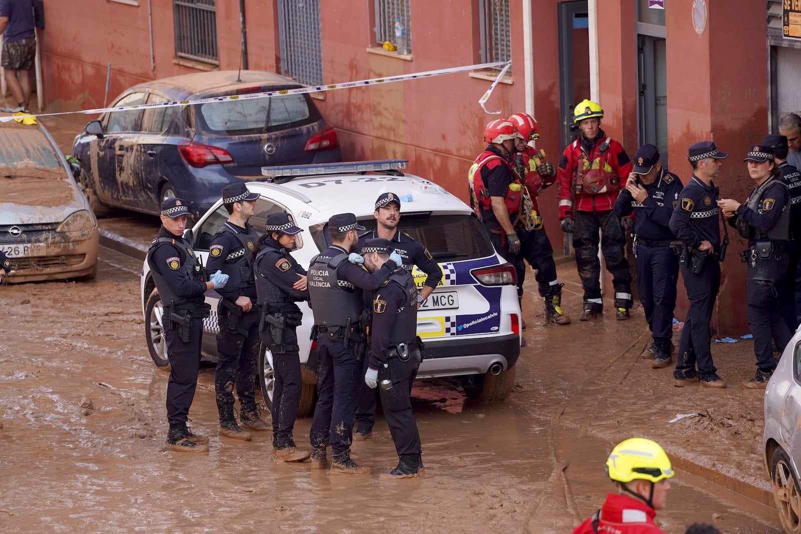 Members of the local police react to the news of one of their colleagues who died in the floods in Valencia, Spain, Thursday, Oct. 31, 2024. (AP Photo/Alberto Saiz)