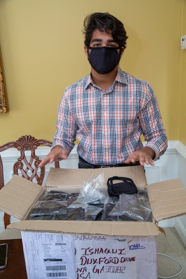 Westminster School senior Azeez Ishaqui looks through a box of face masks sewn by women from India that he plans to donated to three different shelters in Metro Atlanta. He was a high school freshman when he started helping the poor in India, first providing carts for men selling goods, and then later providing sewing machines for widows so they could earn a living. His parents are both from India, and he has always been encouraged to help the poor there.  PHIL SKINNER FOR THE ATLANTA JOURNAL-CONSTITUTION.