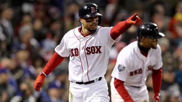 Mookie Betts #50 of the Boston Red Sox celebrates scoring a run on a two-run single by J.D. Martinez (not pictured) during the fifth inning against the Los Angeles Dodgers in Game Two of the 2018 World Series at Fenway Park on October 24, 2018 in Boston, Massachusetts. Betts recently gave food to homeless outside of the Boston Library.