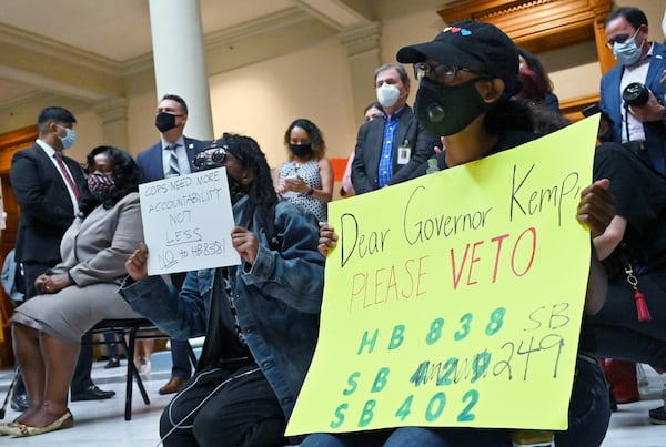 June 26, 2020 Atlanta - Activists holds sign to protest before Gov. Brian Kemp signs HB 426, hate-crimes legislation, into law on the last day of the legislative session at Georgia State Capitol on Friday, June 26, 2020. Gov. Brian Kemp signed hate-crimes legislation into law on Friday after state lawmakers brokered a compromise over the proposal after 16 years of debate over whether to extend protections to people who are targeted because of biases. (Hyosub Shin / Hyosub.Shin@ajc.com)