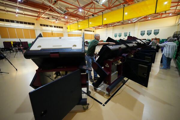 John Farnsworth sets up voting machines at the Hynes Charter School in New Orleans on Election Day, Tuesday, Nov. 5, 2024. (AP Photo/Gerald Herbert)