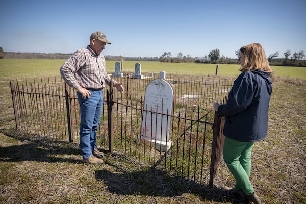 Farmers and landowners Ray Davis and his wife, Belinda Davis, stand near the grave of John C. Davis in the center of a field on Wednesday, Feb. 21, 2024 near Brooklet, Ga. (AJC Photo/Stephen B. Morton)