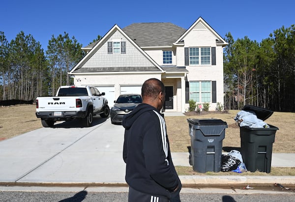 Pernell Evans, homeowner at Parkview Estates in South Fulton, walks by a smaller and lower quality home for rent (background) in his neighborhood. Hyosub Shin / Hyosub.Shin@ajc.com