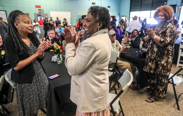 March 31, 2023 Atlanta: Lelia Bolden (left), sister of former firefighter Lisa Bradley, stands to be recognized along with former firefighter Louvenia Jenkins (center)  and retired Battalion Chief Liz Summers (right) during Friday's event. The Atlanta Fire Rescue Department honored the first African American men and women firefighters hired by the City of Atlanta on the 60th anniversary of the AFRDÕs integration on April 1, 1963, and in 1977, respectively. The event was held at fire station 16 located at 1048 Joseph E. Boone Boulevard NW in Atlanta. The first African American firefighters and their representatives in attendance were presented with a sentimental gift for their contributions. (John Spink / John.Spink@ajc.com)

