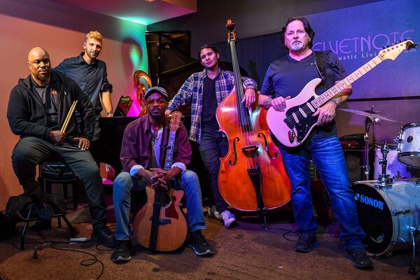 Pictured are most of the Niles Rivers Band members. Raheem Miles, in the front on the left, is no longer a member of the group. From left to right are Caleb Hensinger (back left), Niles Rivers, Chris Sanchez and Bill Hart. The musicians posed for a photo during the band's first rehearsal in November at The Velvet Note in Alpharetta. (Daniel Varnado/For the AJC)