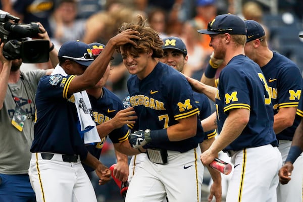 Michigan's Jesse Franklin (middle) is greeted by teammates after he hit a solo home run in the College World Series on June 17, 2019. (AP Photo/Nati Harnik)