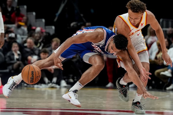 Atlanta Hawks guard Dyson Daniels (5) and Philadelphia 76ers guard Quentin Grimes (5) vie for a loose ball during the first half of an NBA basketball game, Monday, March 10, 2025, in Atlanta. (AP Photo/Mike Stewart)