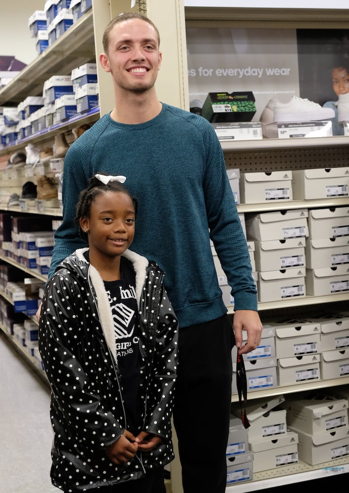 Kendyal Freeman, 8, poses with UGA Quarterback Carson Beck who was on site at an Athen Academy store Sunday December 17, 2023, to give out gift cards to lucky members of area Boys and Girls Clubs. Academy Sports and Outdoors contributed $200 for each child and he kicked in $135 more of his own money to help families out. 

credit: Nell Carroll for the AJC