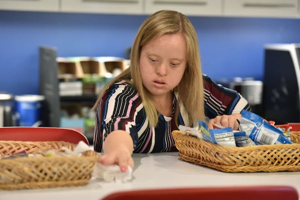 Alex Goodman cleans a desk at Rural Sourcing, where she interns though Georgia Tech’s EXCEL program for students with intellectual disabilities. 