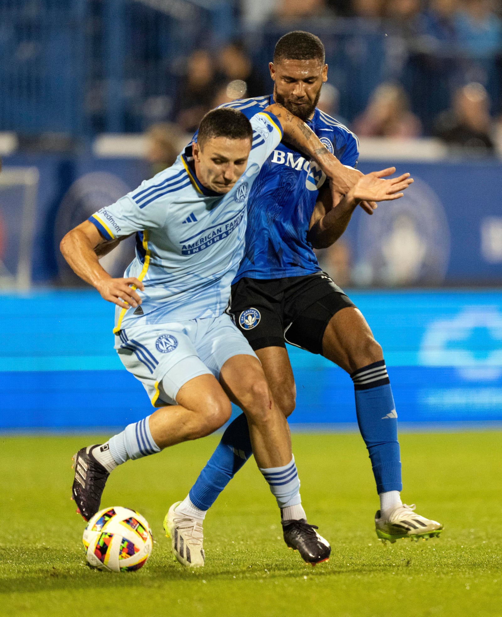 Atlanta United midfielder Bartosz Slisz, left, defends against CF Montreal defender George Campbell the first half of an MLS playoff soccer game in Montreal, Tuesday, Oct. 22, 2024. (Christinne Muschi/The Canadian Press via AP)